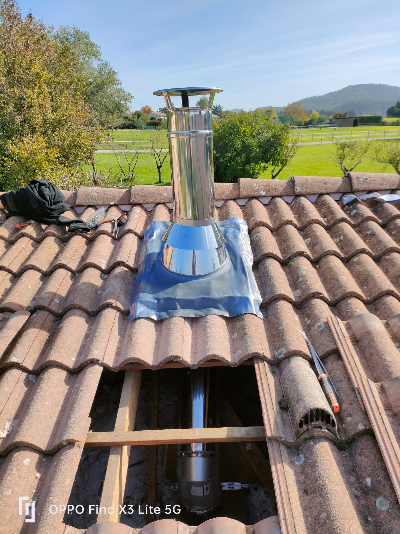Pose d'une sortie de toit inox avec abergement d'étanchéité sur une toiture en tuiles