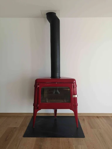 Poêle à bois installé sur un mur en pierres à Volx